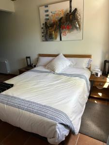 a bedroom with a large bed with white sheets and pillows at Can Roura in Rocabruna