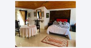 a bedroom with a bed and a table in it at Hotel Rural La Esperanza in Suesca