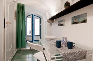 a dining room with a table and a green curtain at Casa Vacanza La Giosa in Sperlonga