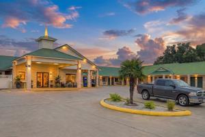a truck parked in a parking lot in front of a building at OYO Hotel Yoakum West in Yoakum