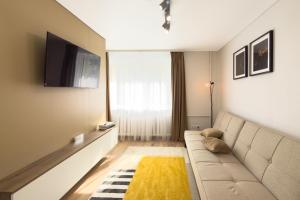 a living room with a couch and a television at AC Vienibas Square apartments in Daugavpils