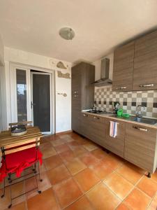 a kitchen with wooden cabinets and a table with a red chair at Il Casale di Nonna Bambina in Francavilla al Mare +27 photos