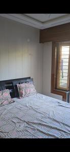 a bedroom with a large bed with a patterned blanket at RYIZ Villa in Agra