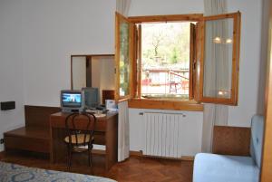 Zimmer mit einem Schreibtisch, einem Computer und einem Fenster in der Unterkunft Hotel Archimede in Reggello