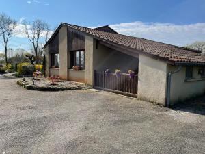 a small house with a fence and a driveway at La dame du bois in Gramat