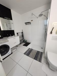 a white bathroom with a shower and a sink at NK Apartment in Bobigny in Bobigny +15 photos