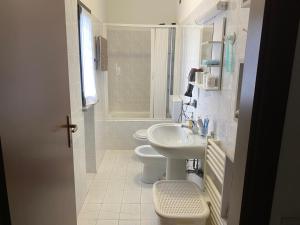 a white bathroom with a sink and a toilet at Matì 2 con navetta 25Eur in Lonate Pozzolo