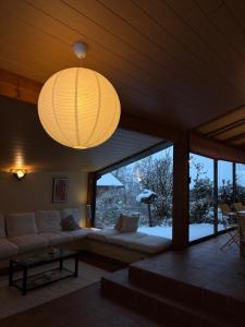 a living room with a couch and a chandelier at Les Hauts du Lac in Gérardmer +16 photos