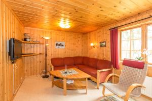 uma sala de estar com um sofá e uma mesa em Sörmons Stugby em Ljusnedal