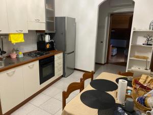 a kitchen with a table and a stove and refrigerator at Matì 2 con navetta 25Eur in Lonate Pozzolo