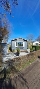 a small house with a window on a driveway at Comfortable Chalet in Berkhout