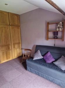 a living room with a blue couch and wooden cabinets at Chez Bya in Bouvellemont