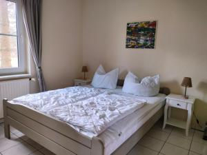 a bedroom with a bed with white sheets and pillows at Lenzer Ferienidyll am Plauer See in Lenz +25 photos
