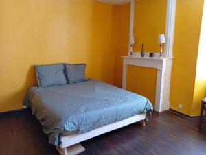 a bed in a room with a yellow wall at Les Lavandières in Satillieu