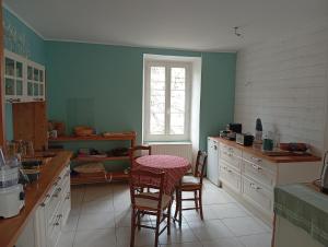 a kitchen with a table and chairs and a window at Les Lavandières in Satillieu