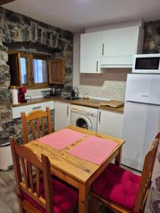 a kitchen with a wooden table and a white refrigerator at Loft Miradas al Sella in Corigos