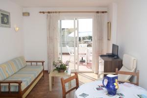 ein Wohnzimmer mit einem Sofa und einem Tisch in der Unterkunft Sa Marina in Cala Millor