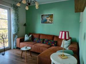 a living room with a brown couch and a table at Lenzer Ferienidyll am Plauer See in Lenz