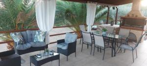 a living room with a table and chairs on a porch at Andre House in Mesimvría