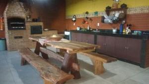 a kitchen with wooden tables and a kitchen with a counter at Sossego e Lazer na Serra do Cipó, piscina e Rio in Jaboticatubas