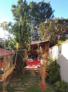 a house with a garden in front of it at Sossego e Lazer na Serra do Cipó, piscina e Rio in Jaboticatubas