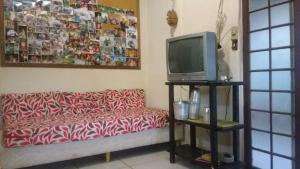a living room with a couch and a tv at Sossego e Lazer na Serra do Cipó, piscina e Rio in Jaboticatubas