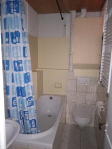 a bathroom with a tub and a toilet and a sink at Chambre A 1er étage in Biel