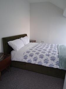 a bedroom with a bed with a blue and white comforter at Morecambes wise place in Morecambe