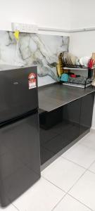 a desk with a refrigerator in a room at arin syah homestay in Jasin