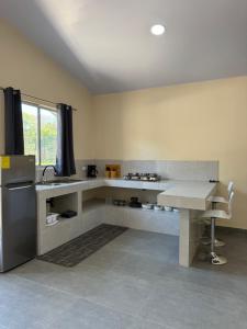a kitchen with a counter and a table in it at Apartamentos el Bosque in Jacó