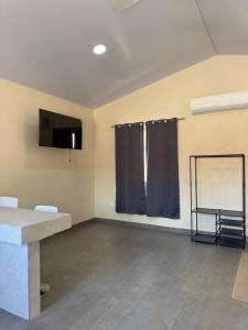an empty room with a table and a window at Apartamentos el Bosque in Jacó
