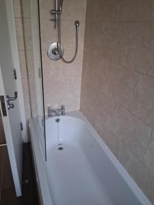 a bath tub in a bathroom with a shower at Morecambes wise place in Morecambe