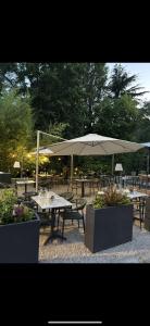 a group of picnic tables with an umbrella at Le Molineuf in Orchaise