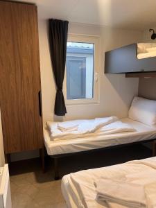 two beds in a room with a window at Camping Resort Riegersburg in Riegersburg +76 photos