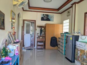 a room with a kitchen with a refrigerator and a table at Chez ma mère Homestay in Ko Chetmun