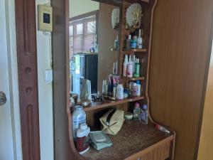 a vanity with a mirror in a room at Chez ma mère Homestay in Ko Chetmun