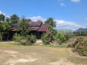 a house with a red roof and some flowers at Chez ma mère Homestay in Ko Chetmun