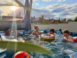 a group of people in a swimming pool at NikoLux Apartman in Hajdúszoboszló