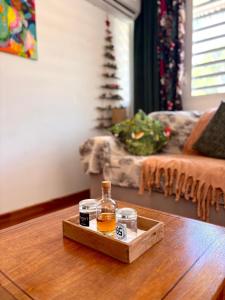 a tray with a bottle of whiskey on a table at Bungalow Agathe - Piscine, Wifi, Farnienté et Plage à 2 minutes in Grand-Bourg