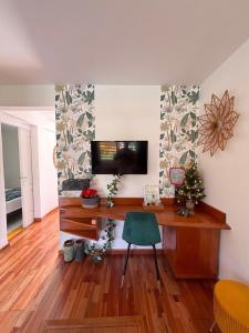 a living room with a television and a desk with a christmas tree at Bungalow Agathe - Piscine, Wifi, Farnienté et Plage à 2 minutes in Grand-Bourg