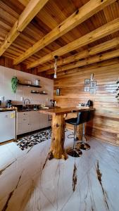 a kitchen with a wooden ceiling and a wooden table at Cabanas Céu e Mel - Cabana 01 in Bom Retiro