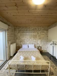 a bedroom with a bed in a brick wall at D&M LIVING STUDIO Patra in Patra