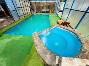 a large blue swimming pool in a building at Hostal El Amigo Lucho in San Pedro de Atacama
