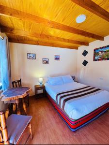 a bedroom with a bed and a wooden ceiling at Hostal El Amigo Lucho in San Pedro de Atacama +87 photos