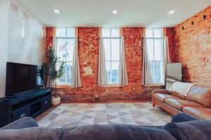 a living room with a couch and a tv at American Hall - Kaufman Suite in Millersburg