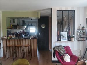 a kitchen and a living room with a red chair at chambre double in Poitiers +2 photos