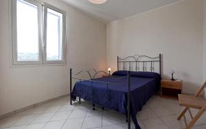 レウカにあるCasa del Sole by BarbarHouseのベッドルーム1室(青いベッドカバー付)、窓2つが備わります。