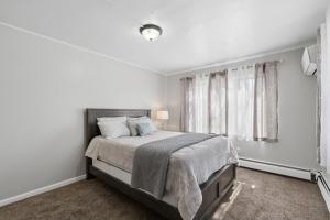 a white bedroom with a bed and a window at Home In Highland Park in Saint Paul