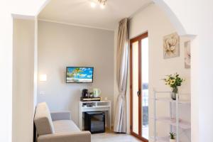 a living room with two chairs and a tv at Tauromenion Guest House in Taormina