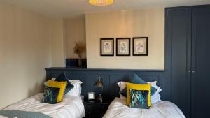a bedroom with two beds with yellow and blue at Jack & Jill Inn Pub in Hassocks